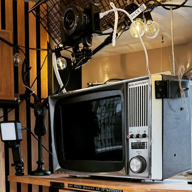 Blick ins Innere: Spiegelreflexkamera und alter Blaupunkt-Fernseher im ausgebauten Anhänger